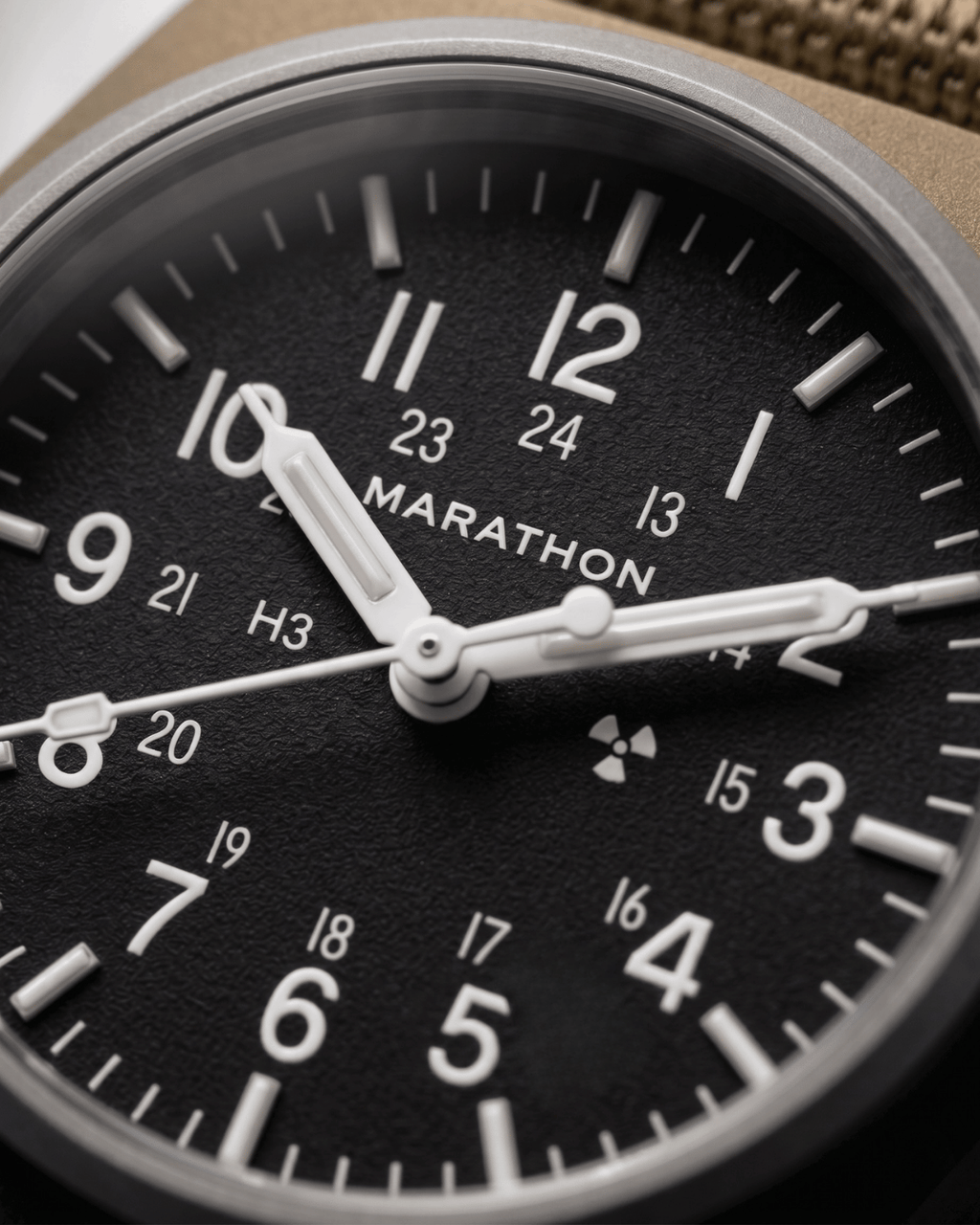 Close-up of the 34mm GPM dial showing Tritium gas tubes for constant visibility and the Marathon automatic movement branding. High-performance military watch.