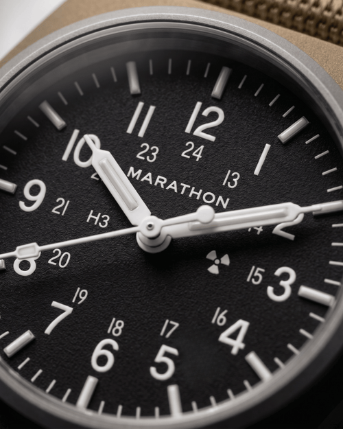 Close-up of the 34mm GPM dial showing Tritium gas tubes for constant visibility and the Marathon automatic movement branding. High-performance military watch.