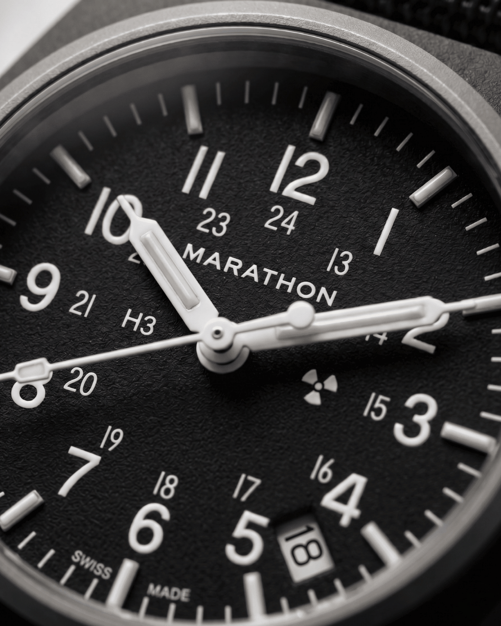 Close-up of the Marathon GPQ dial showing Tritium gas tubes and the Swiss-made 3-Jewel movement details. Professional military watch precision.