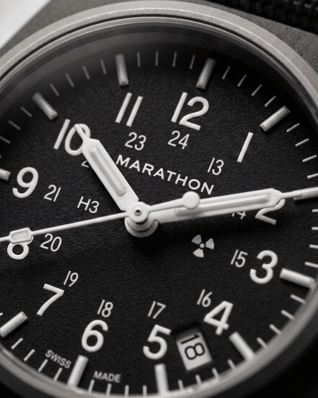 Close-up of the Marathon GPQ dial showing Tritium gas tubes and the Swiss-made 3-Jewel movement details. Professional military watch precision.