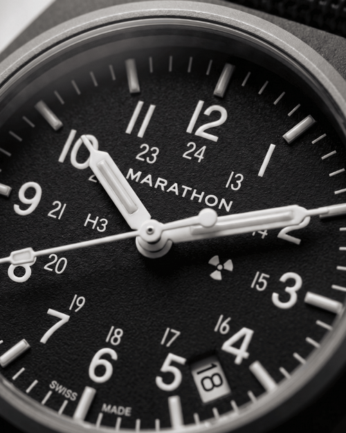 Close-up of the Marathon GPQ dial showing Tritium gas tubes and the Swiss-made 3-Jewel movement details. Professional military watch precision.
