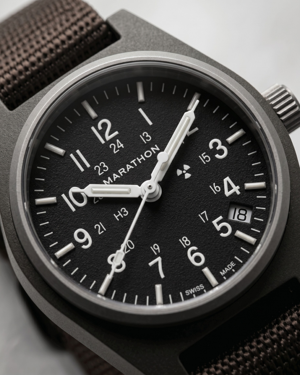 Detailed view of the scratch-resistant sapphire crystal and sterile aesthetic of the Marathon GPQ. Built for durability in high-end quartz watches.