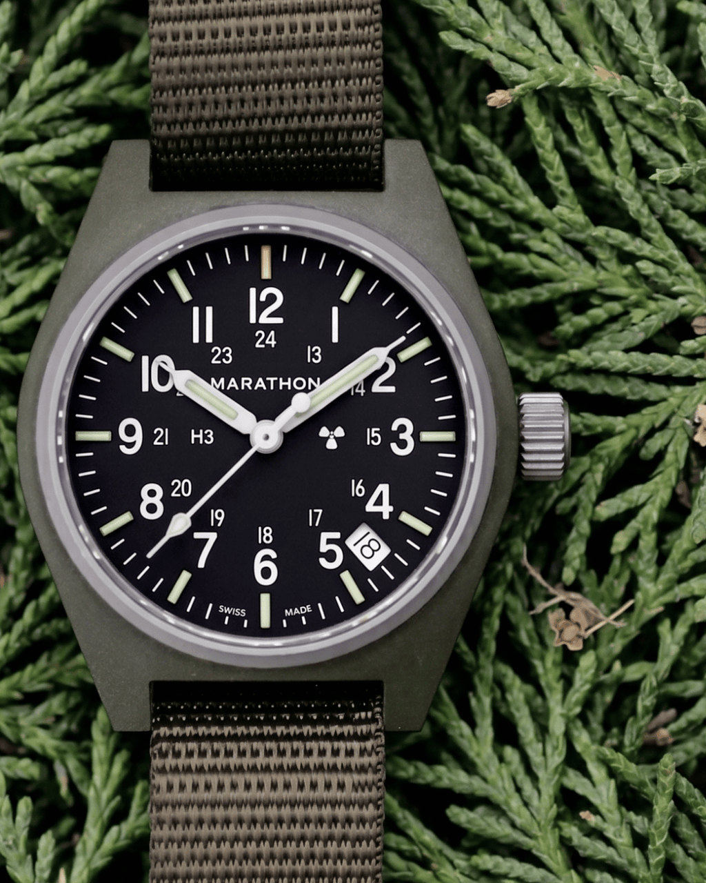 The Marathon Sage Green GPQ in a natural outdoor setting. For those seeking professional watches for men nearby, this is a mission-ready field watch.