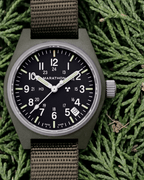 The Marathon Sage Green GPQ in a natural outdoor setting. For those seeking professional watches for men nearby, this is a mission-ready field watch.