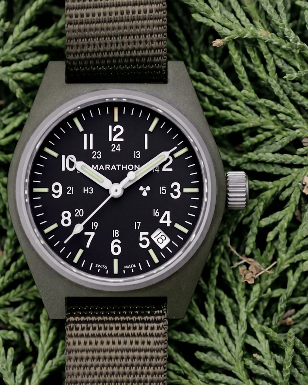 The Marathon Sage Green GPQ in a natural outdoor setting. For those seeking professional watches for men nearby, this is a mission-ready field watch.