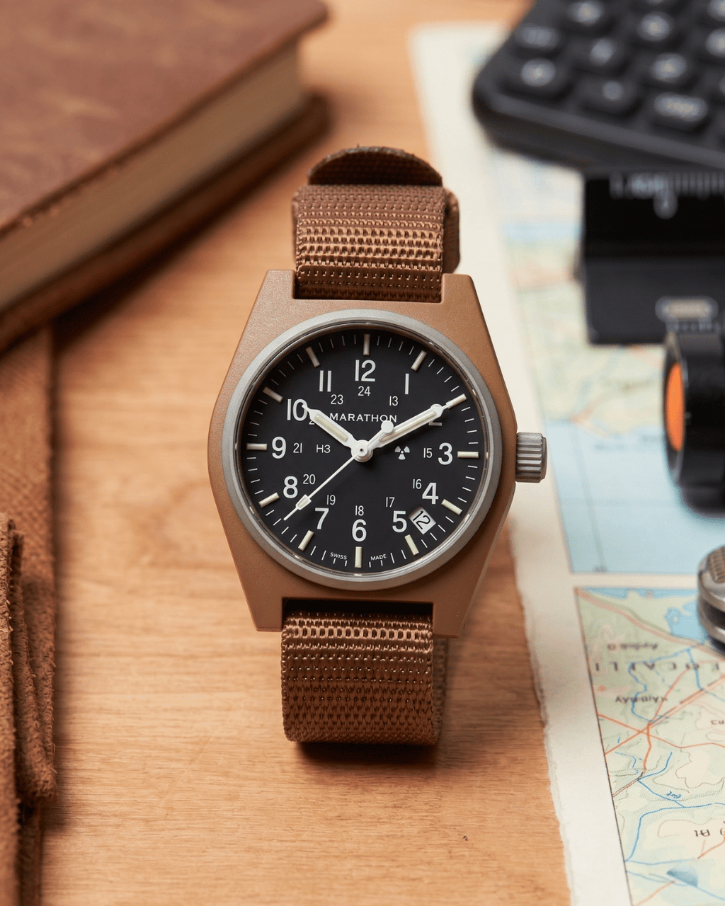 Marathon military watch on desk. Desert Tan GPQ-D style for professional watch collections.